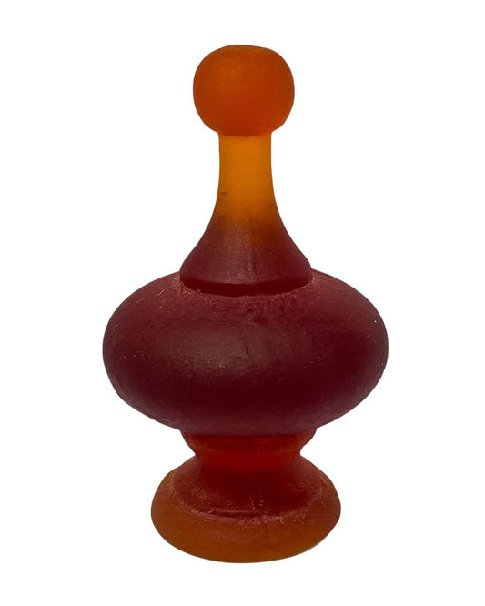 A dark Orange Cast Glass Finial  lit to showcase its intricate curves and varying depths, highlighting the glass's colour tones and translucency.