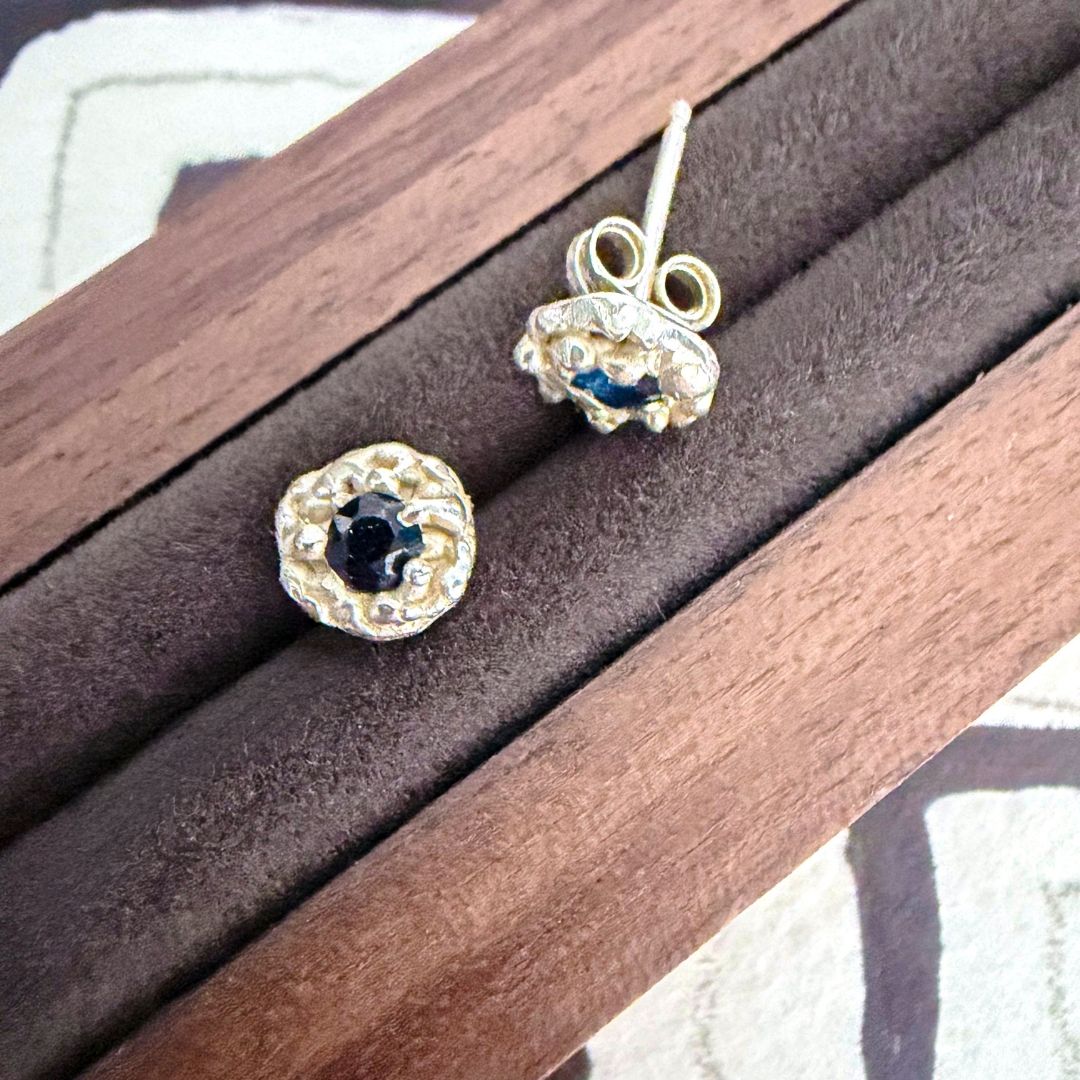 Pair of sterling silver Dewdrop Sapphire Stud Earrings in a wooden jewellery box, showing the organic texture, blue sapphire and butterfly backs.