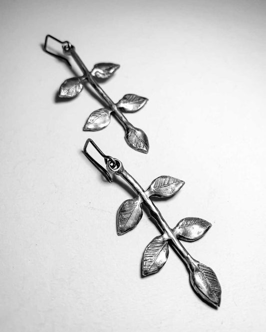 A pair of oxidised Sterling Silver Earrings featuring a stylised plant stem  with 5 leaves. 