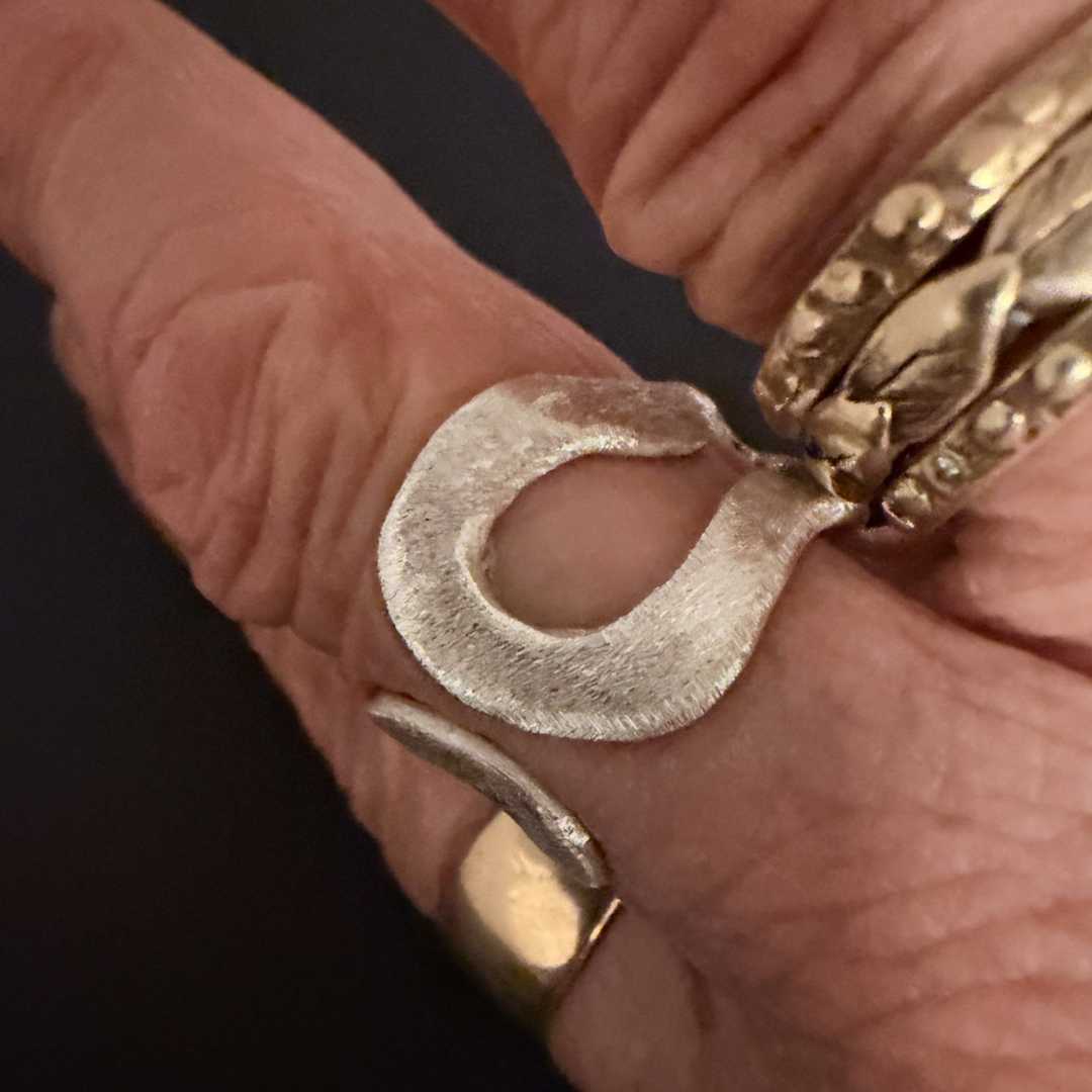 Sterling silver split ring worn on hand alongside gold rings showing mixed metal styling