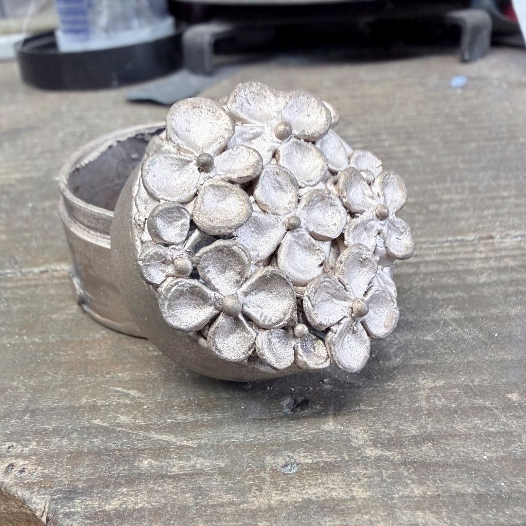 Bronze Hydrangea Box on the jeweller’s bench before patination, showing the layered hydrangea flowers in raw metal.
