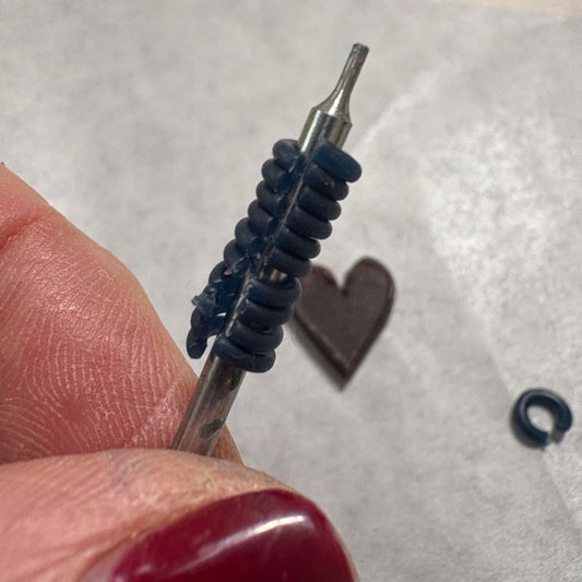 Making wax jump rings for charms in jewellery workshop