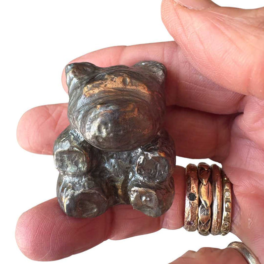 Handcrafted solid cast bronze teddy bear held in hand showing compact 30x37.5mm size