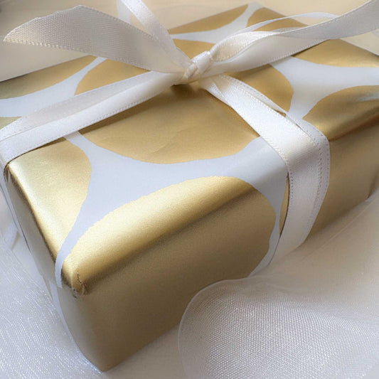 White and gold present with soft tulle bow — lifestyle scene suggesting HerbertandWilks Jewellery Gift Card gifting inspiration