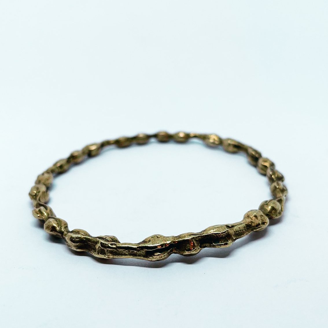 Side angle showing the pod shapes soldered into a continuous bangle form
