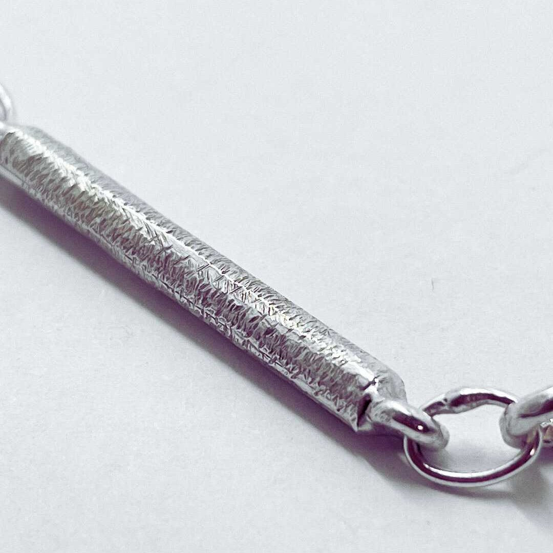 Macro detail of the handcrafted textured link connection on the Sterling Silver Line Chain Necklace, showing the organic surface finish against a clean white background.