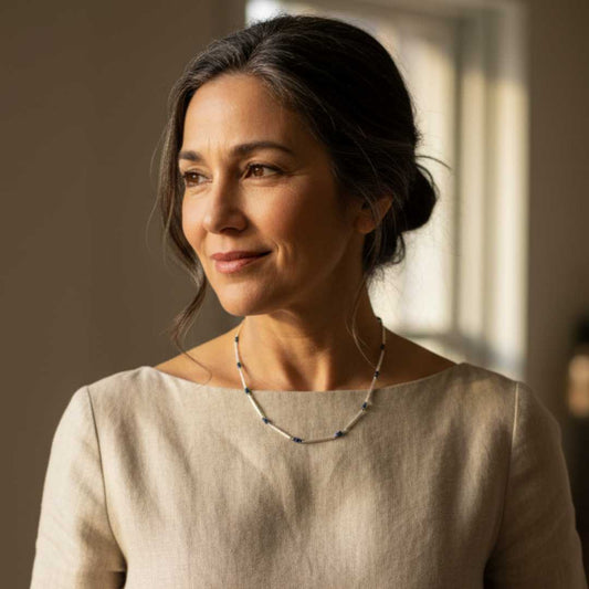 Mature woman wearing sterling silver and blue sapphire chain necklace with architectural linen dress - anniversary jewellery New Zealand