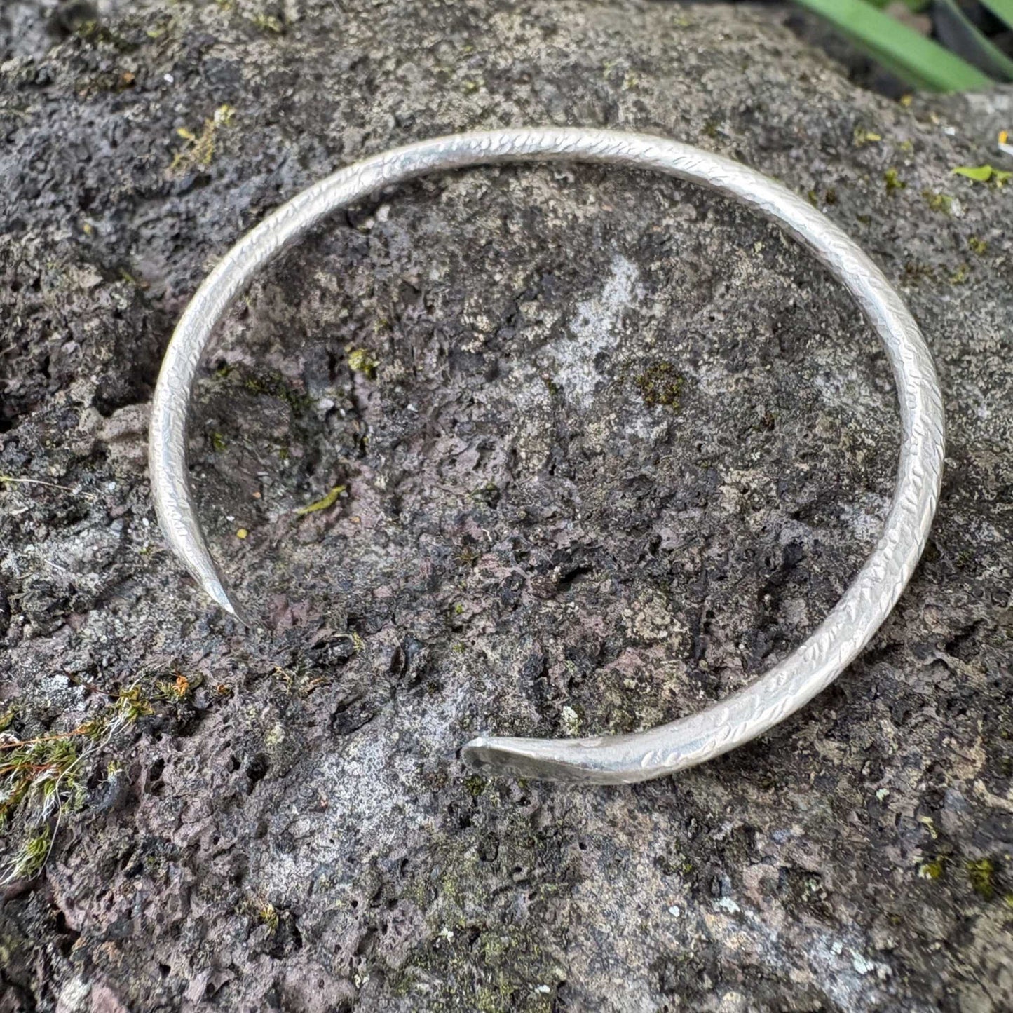 Maker Cuff – hand-forged sterling silver cuff resting on basalt rock from Mt Eden, Auckland, highlighting its natural texture and local inspiration