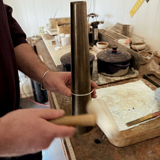 Man shaping a sterling silver cuff with a nylon mallet on a steel mandrel during the Maker Cuff Workshop in Mt Eden, Auckland