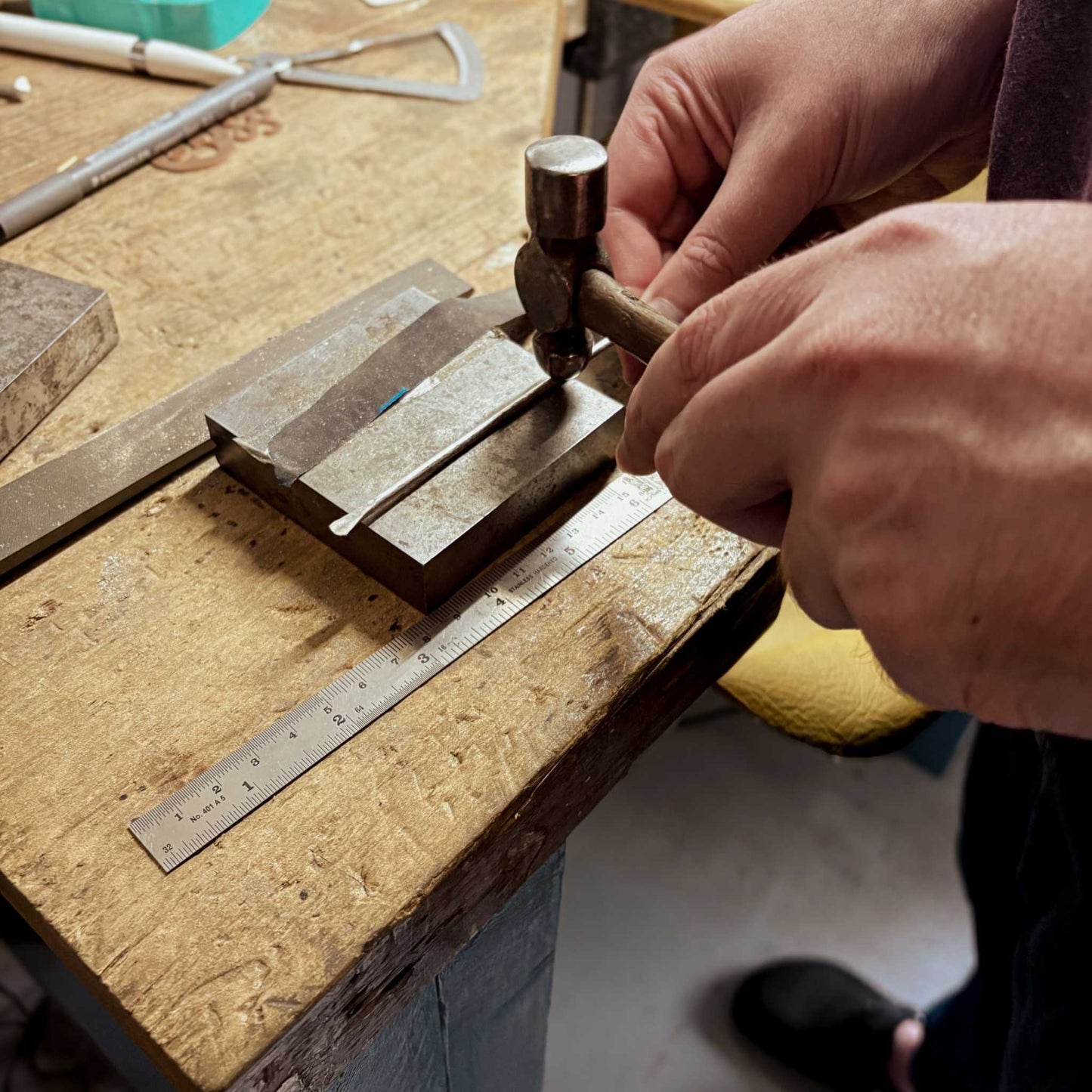 Close-up of hands applying texture along the length of a sterling silver cuff during the Maker Cuff Workshop in Mt Eden, Auckland