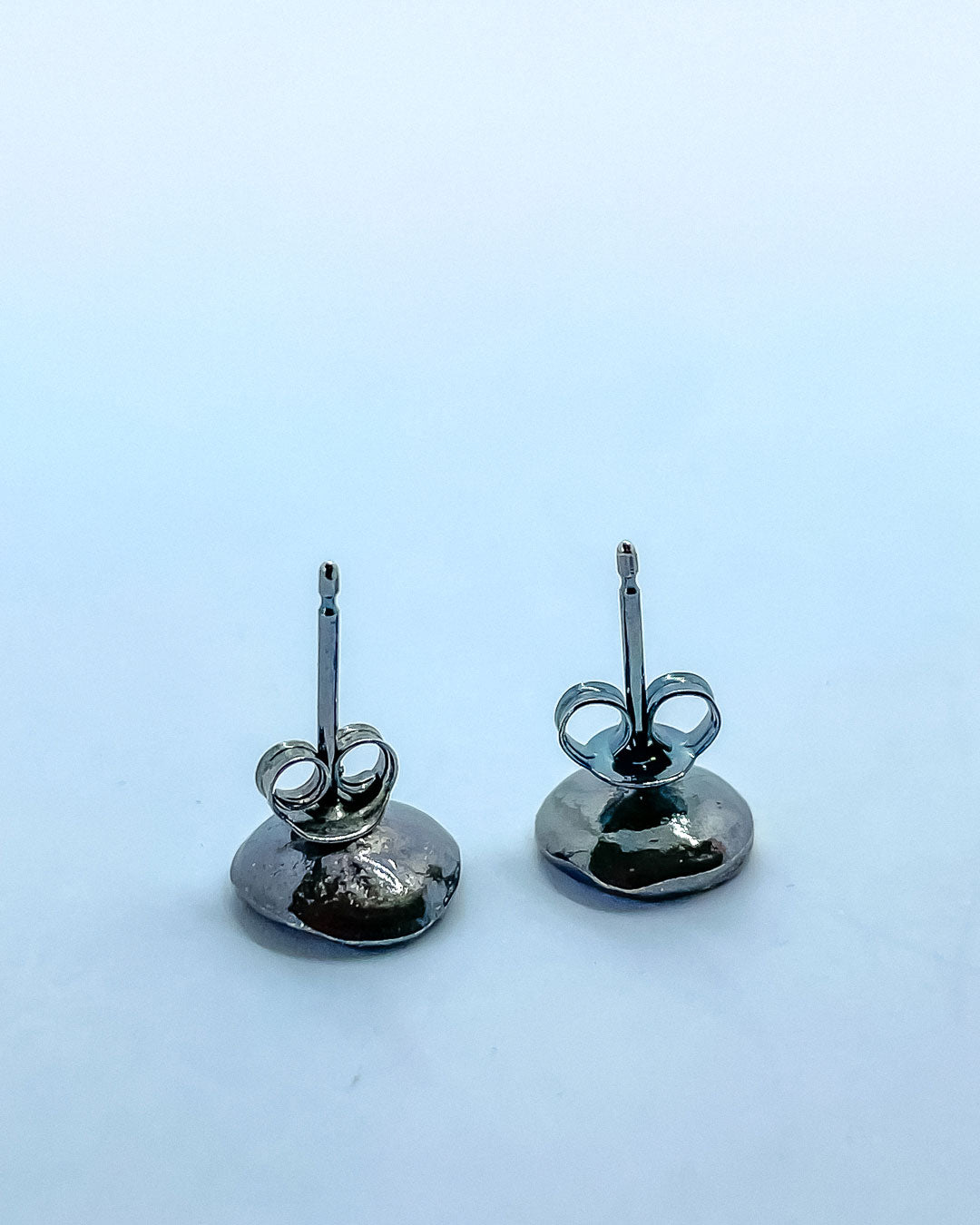 Showing the back of two concave stud earrings