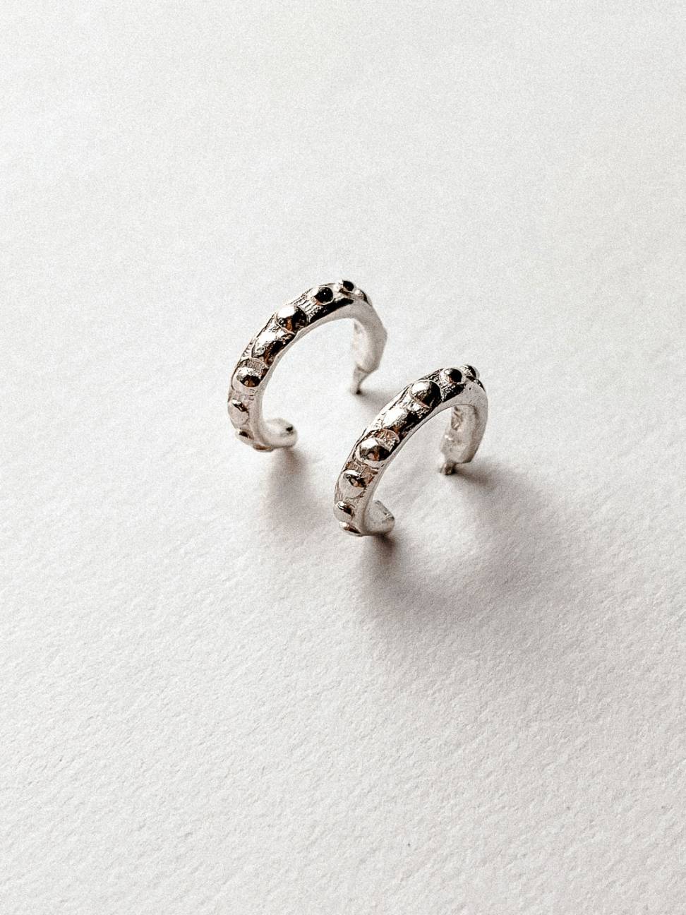 A pair of Hoop Earrings showing the texture using a side profile in Sterling Silver