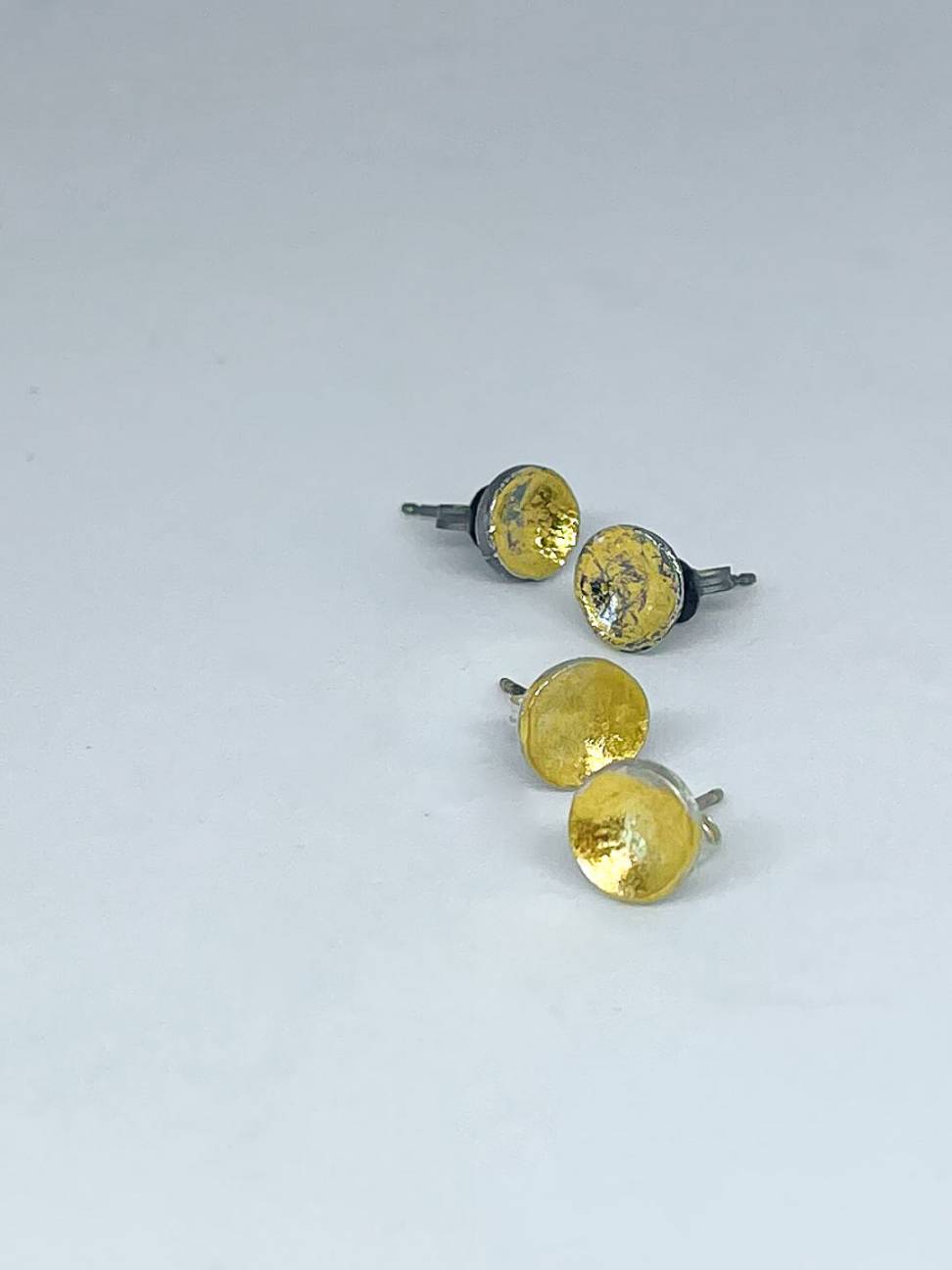 Two pairs of organic Fine Silver concave Stud Earrings displaying the two finishes Oxidised Silver+Gold or Silver+Gold Finish
