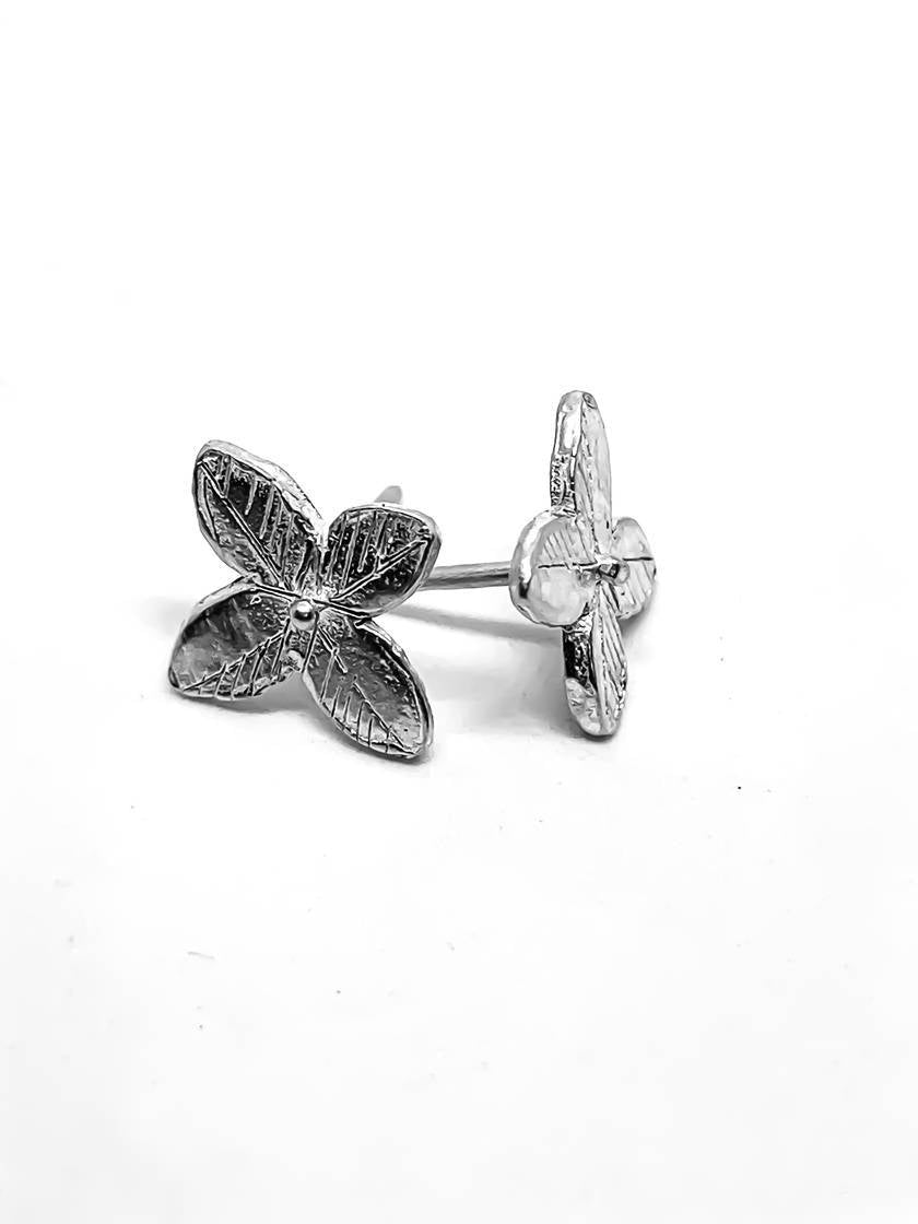 Front and side profile of Primitive four-petal flower stud earrings in Sterling Silver