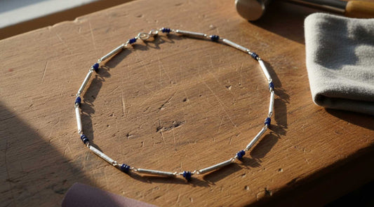 Line chain necklace with blue sapphires on jeweller's bench - everyday jewellery