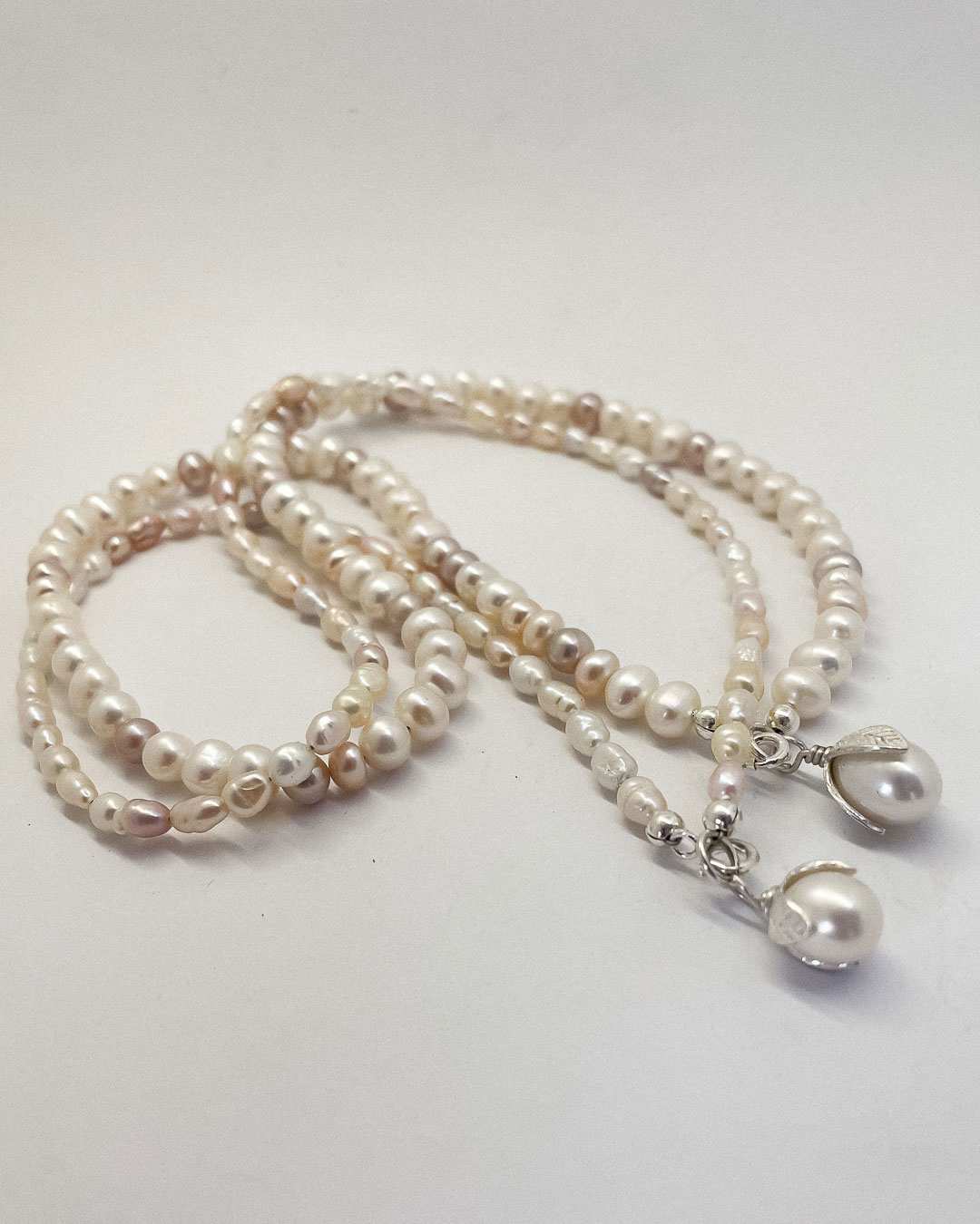 Two one-of-a-kind Glow Pearl Necklaces made from freshwater pearls - each with their own unique, colour, shape and characteristics with a Sterling Silver and Pearl pendant