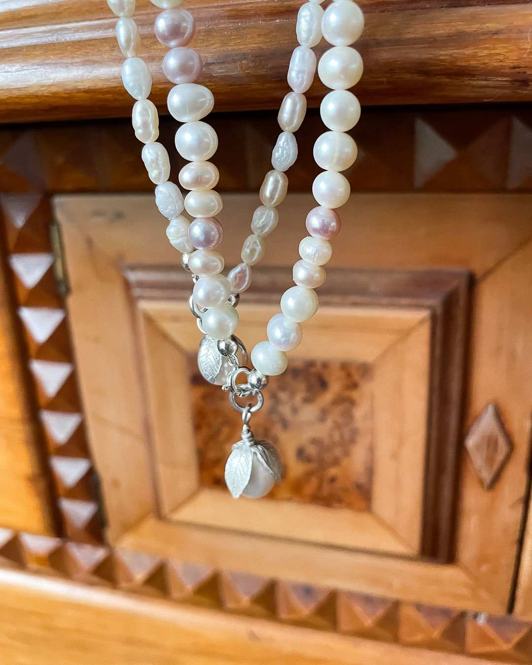 A close up of the Two one-of-a-kind Glow Pearl Necklaces made from freshwater pearls and the Sterling Silver and Pearl pendant
