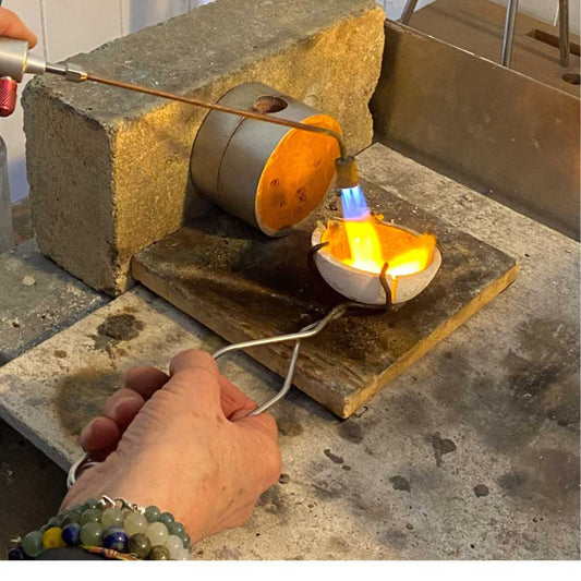 Molten 9ct yellow gold being melted in preparation for sandcasting, showing the handcrafted jewellery making process at HerbertandWilks studio, Auckland