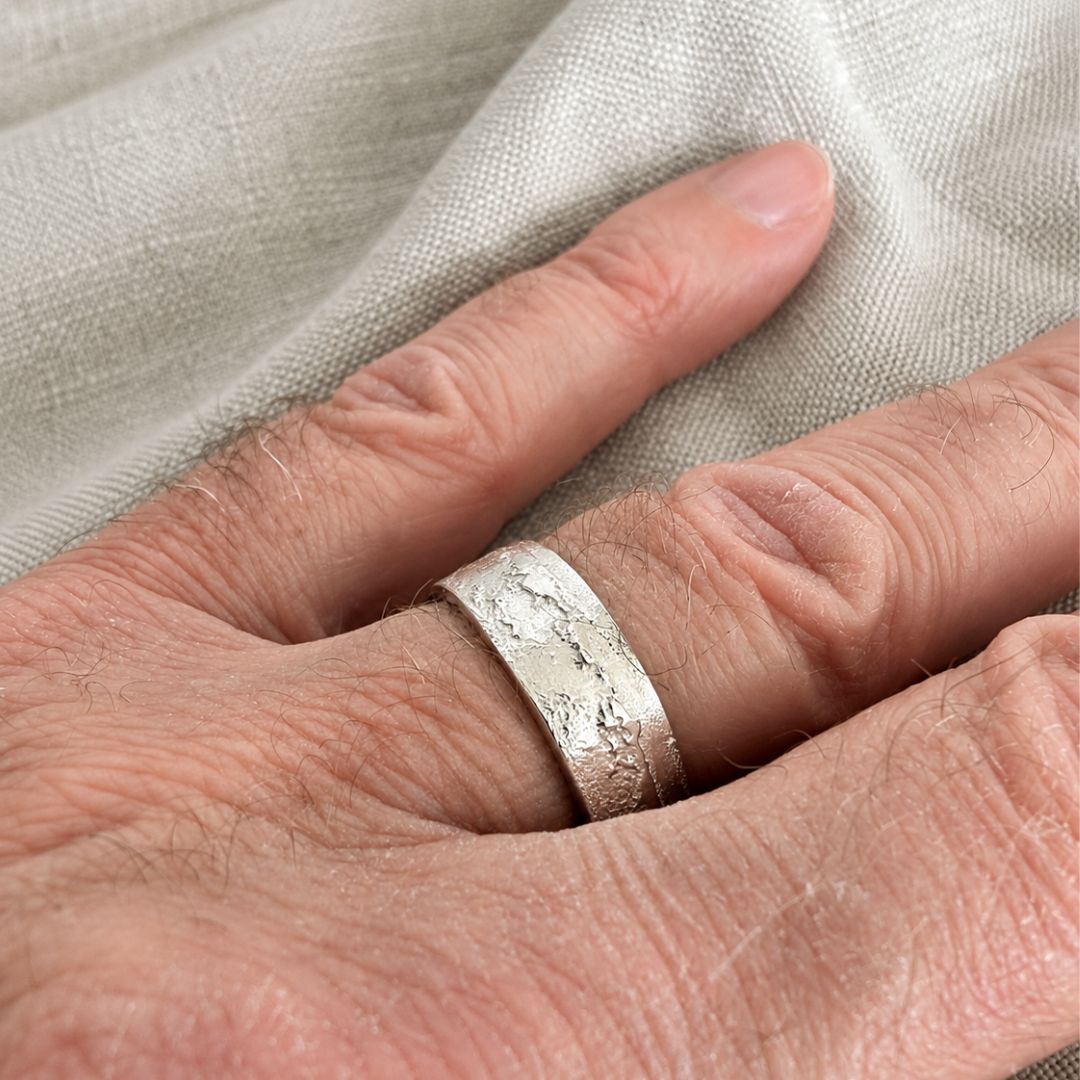 Close-up of 7mm sterling silver sandcast ring showing textured handmade surface while worn