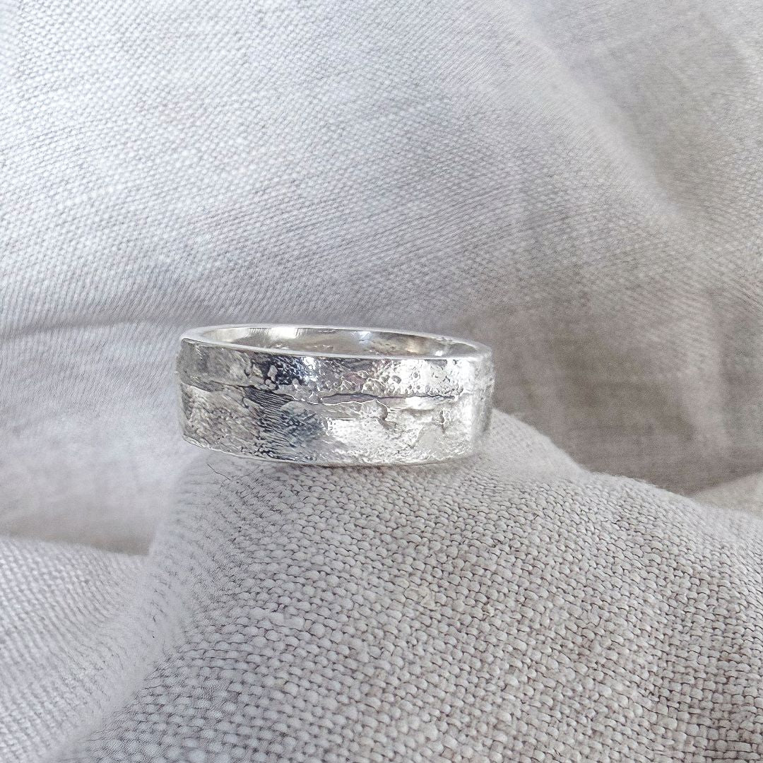 Close-up of 7mm sterling silver sandcast ring showing textured handmade surface while worn