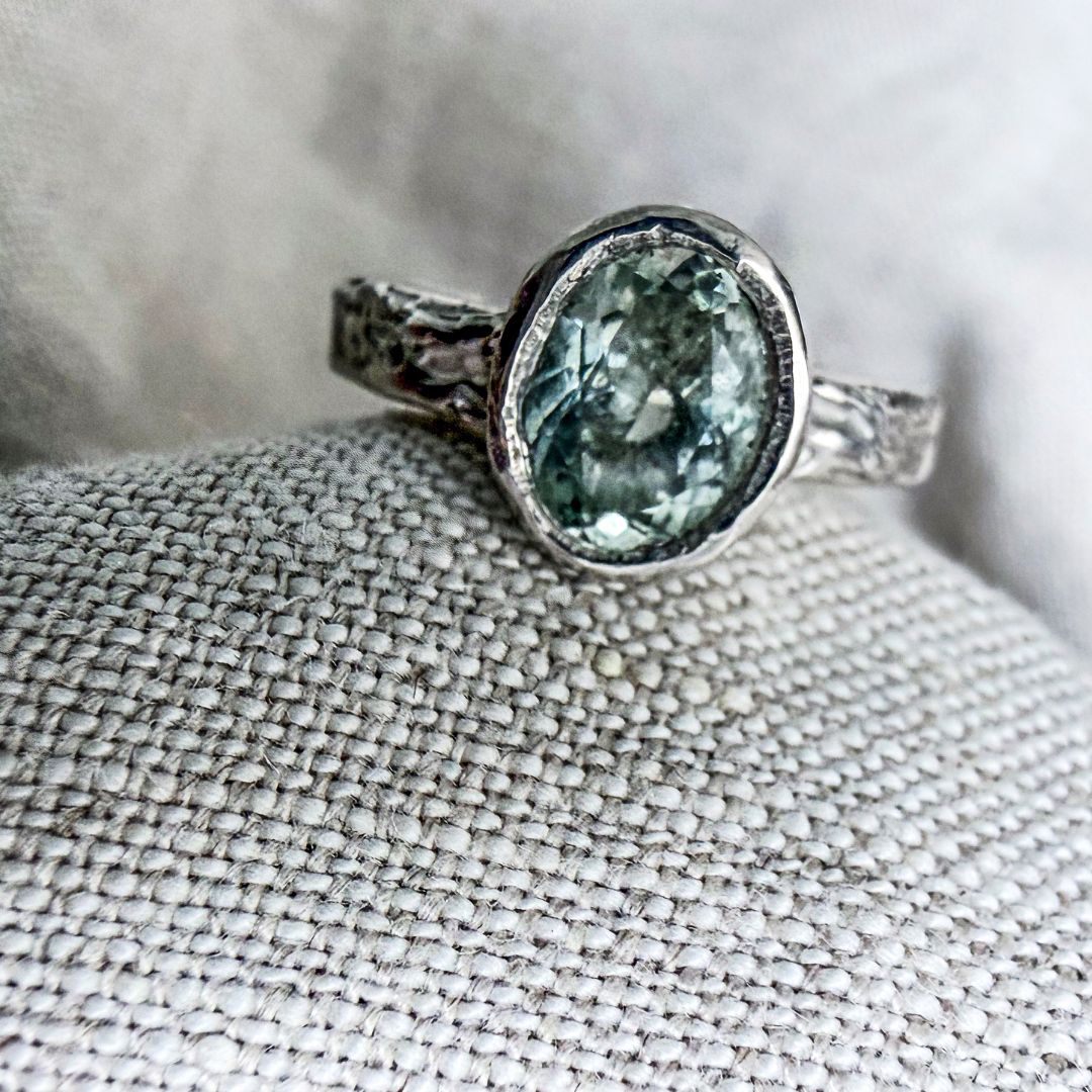 Close-up of the natural oval aquamarine bezel-set in textured sterling silver.