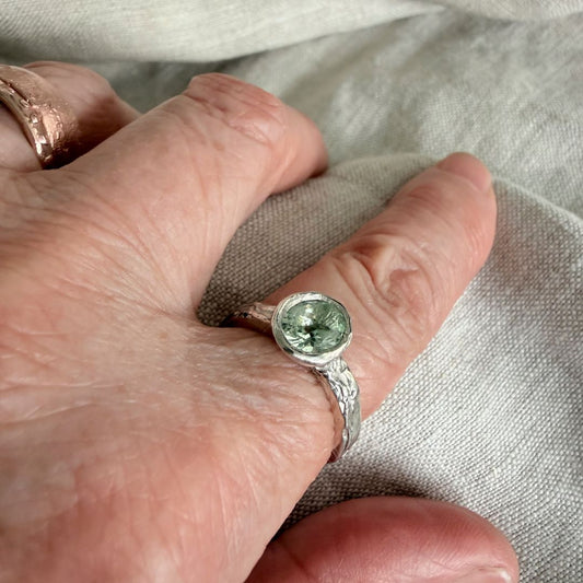 Manatū aquamarine ring worn on the hand, showing the scale of the oval stone and textured sterling silver band.