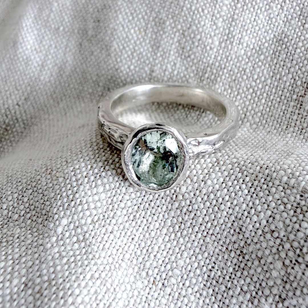 One-of-a-kind Manatū Ring in sterling silver with an oval natural aquamarine and textured handmade band.