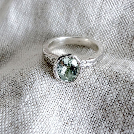 One-of-a-kind Manatū Ring in sterling silver with an oval natural aquamarine and textured handmade band.