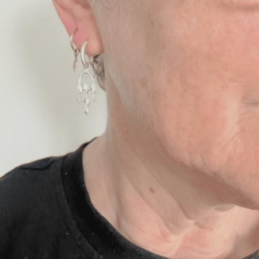 Sterling silver Arbour drop earrings worn on the ear, showing their light open shape and comfortable length.