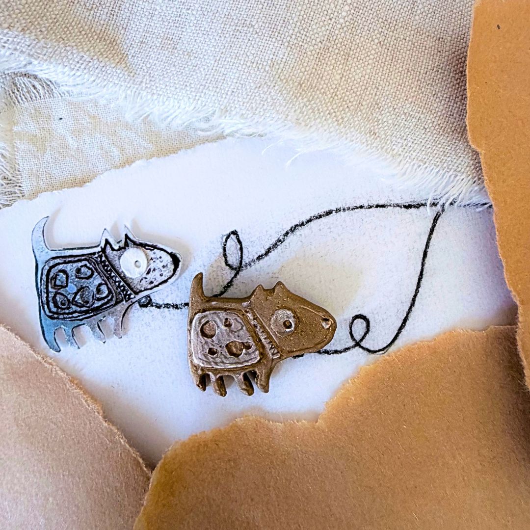 Bronze Dog Pin beside the original hand-drawn dog design