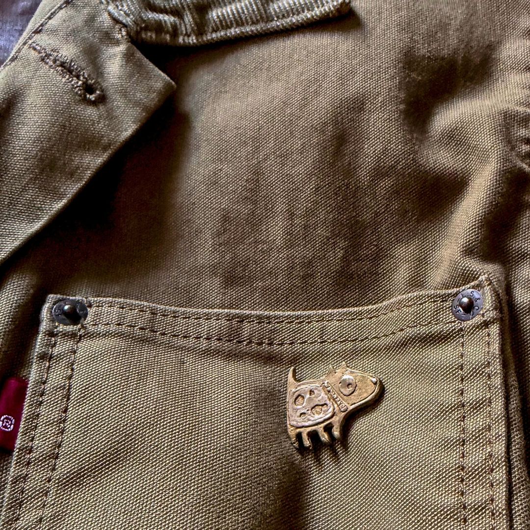 Bronze Dog Pin worn on the pocket of a khaki Levi's Jacket