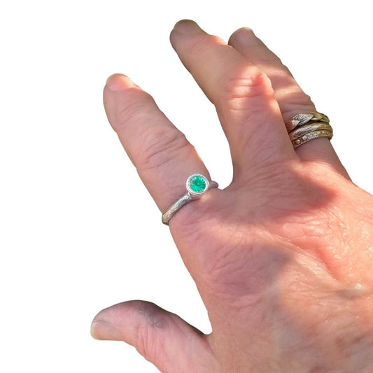 Hand wearing the Edition of One Cherish Ring in sterling silver, Size O, set with 5mm Biron emerald.