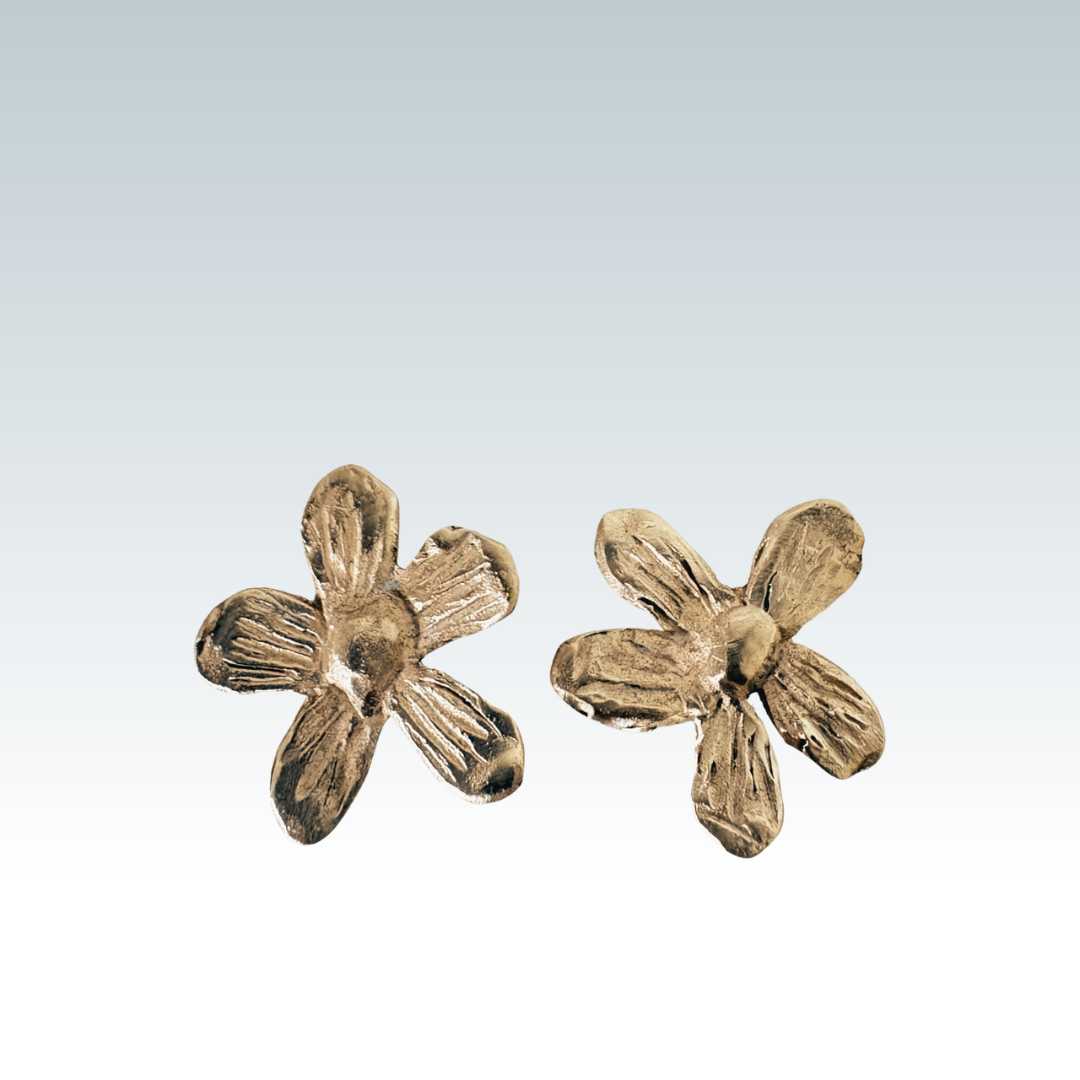 Flora Stud Earrings - 9ct yellow gold flower studs front view showing sculptural petal detail on smokey blue and white background