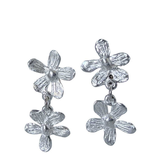 Close-up of Flora Duo Drop Stud Earrings in sterling silver against a white background, showing hand-textured surface detail and whimsical two-flower botanical form. Handmade in Auckland, New Zealand.