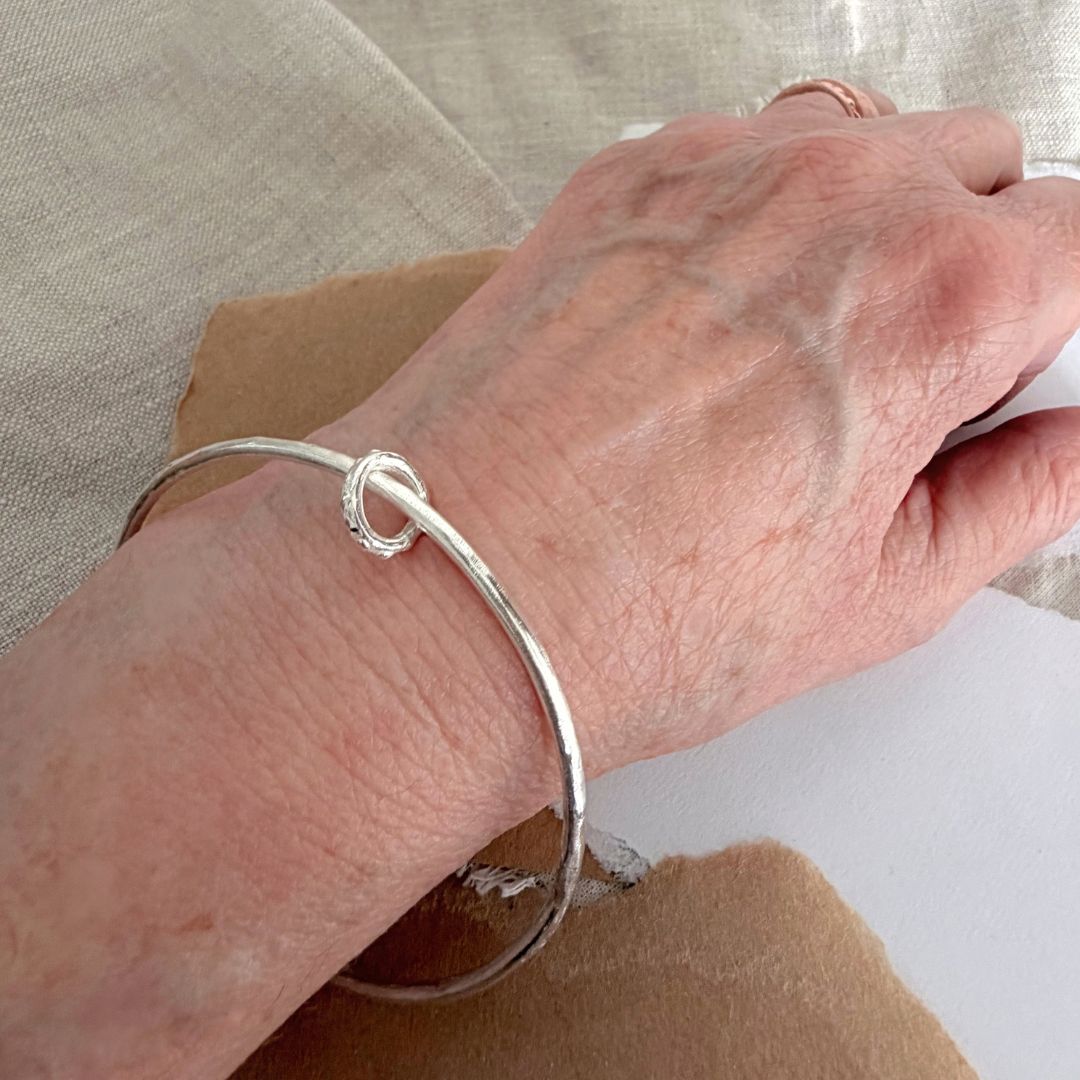 Sterling silver Fluid Ring Bangle worn on the wrist, showing its simple everyday proportions