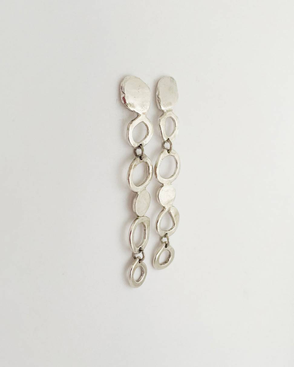 Showing a side profile of a pair of contemporary-designed drop earrings are inspired by the graceful fall of raindrop in Sterling Silver
