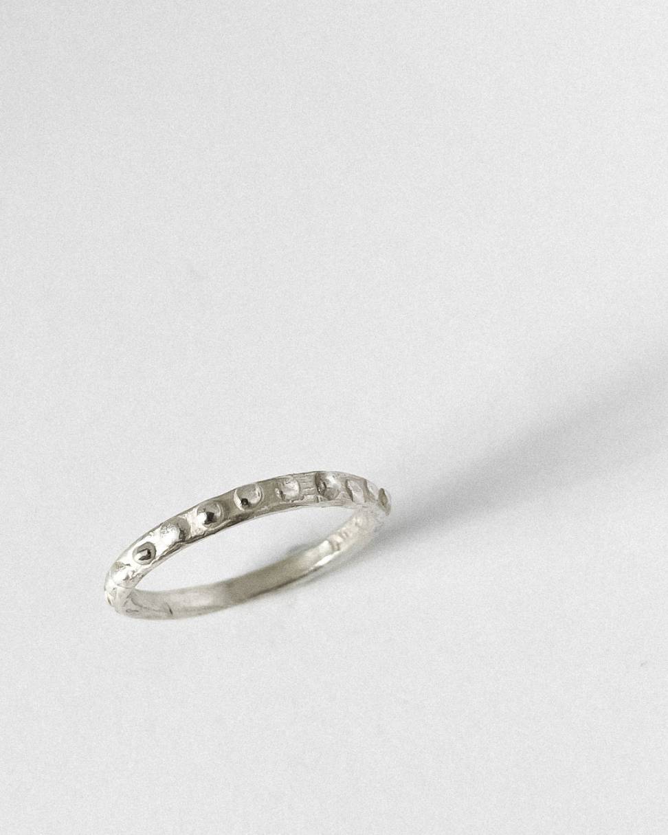 looking down onton a sterlin silver narrow Textured Ring band showing the primitive organic textured surface. 