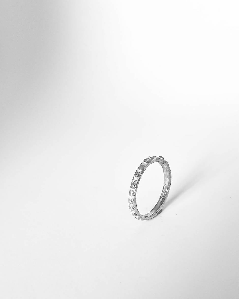 A Narrow Textured Stacking Ring with a primitive organic textured surface in sterling silver