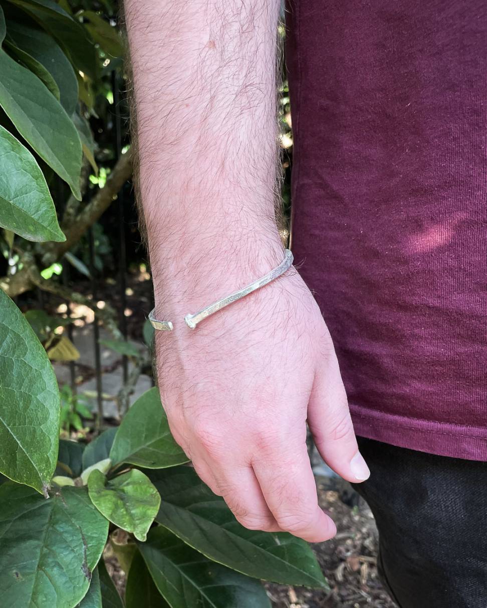 A close up image of the Sterling Silver Sheet Cut Nail Cuff worn on a male model