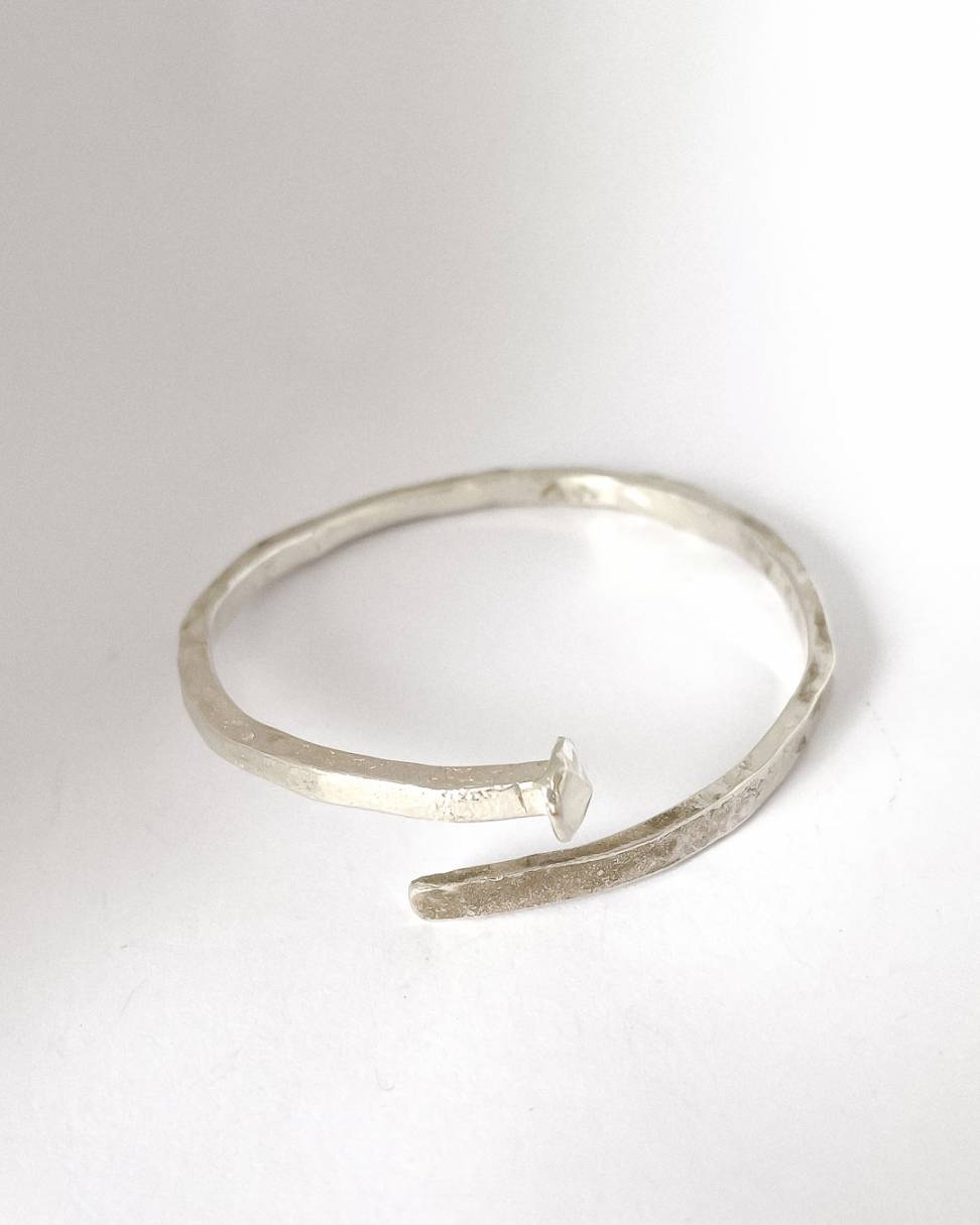 A close up image of a Sterling Silver Sheet Cut Nail Cuff which is a unisex cuff bangle inspired and created from a 19th-century sheet Cut nail that our family found in an early workers' cottage in the Auckland suburb of Mt Eden. 