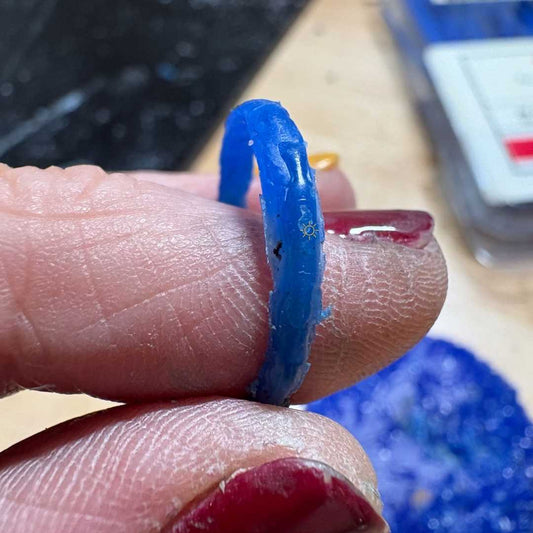 Blue wax ring held between fingers - wax build-up technique for stacking ring workshop