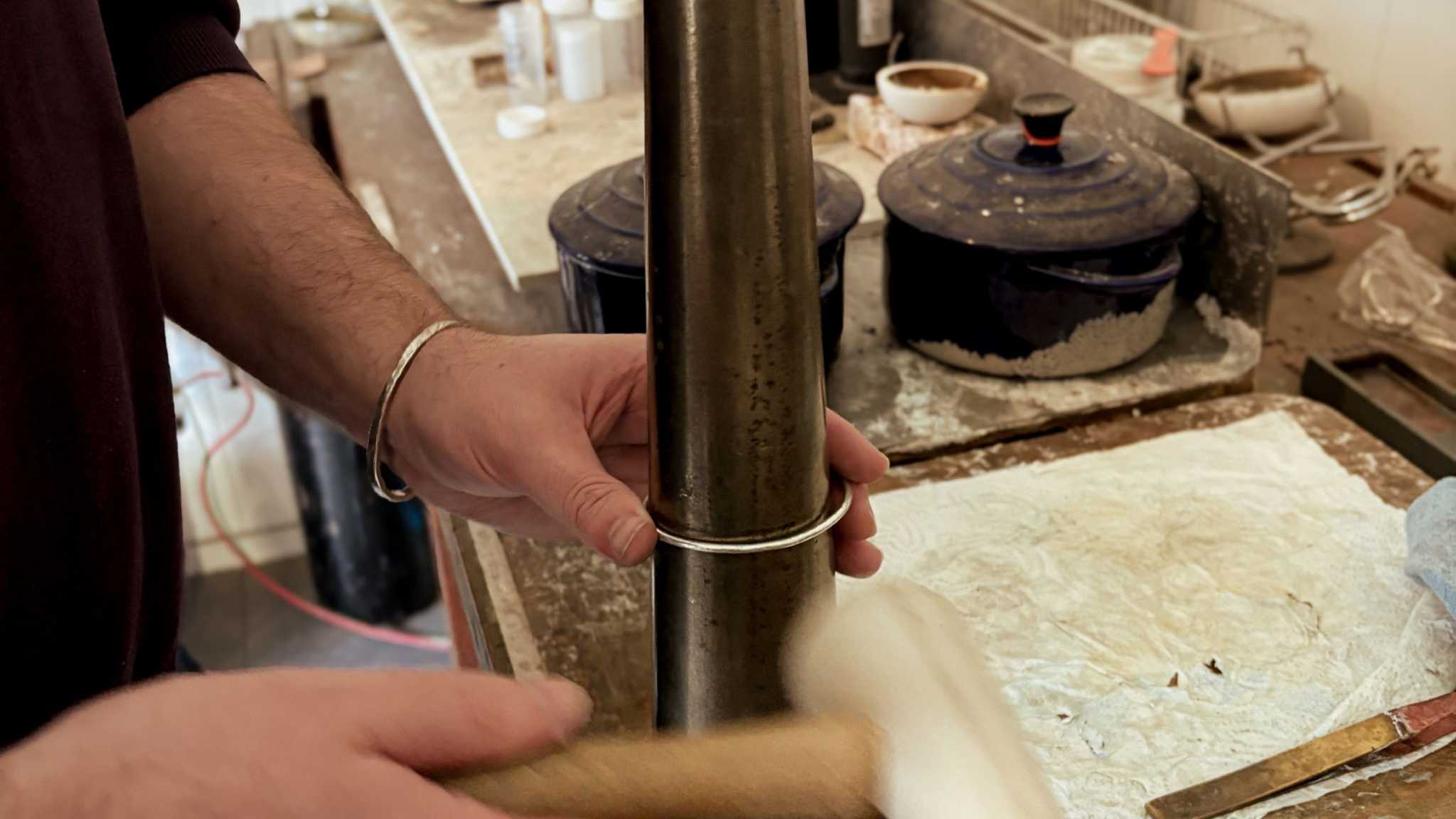 Hands shaping a sterling silver cuff on a steel mandrel during the Maker Cuff Workshop in Mt Eden, Auckland