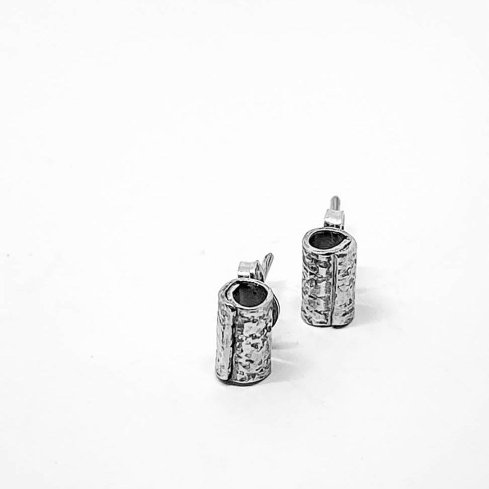 Fine silver wrapped mini stud earrings standing on white background showing textured cylindrical form