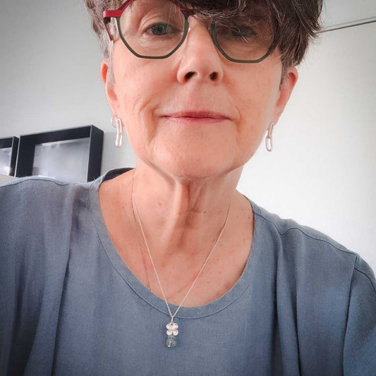 Woman wearing hydrangea flower necklace with aquamarine beads in sterling silver, handcrafted by HerbertandWilks Jewellery in Auckland, New Zealand