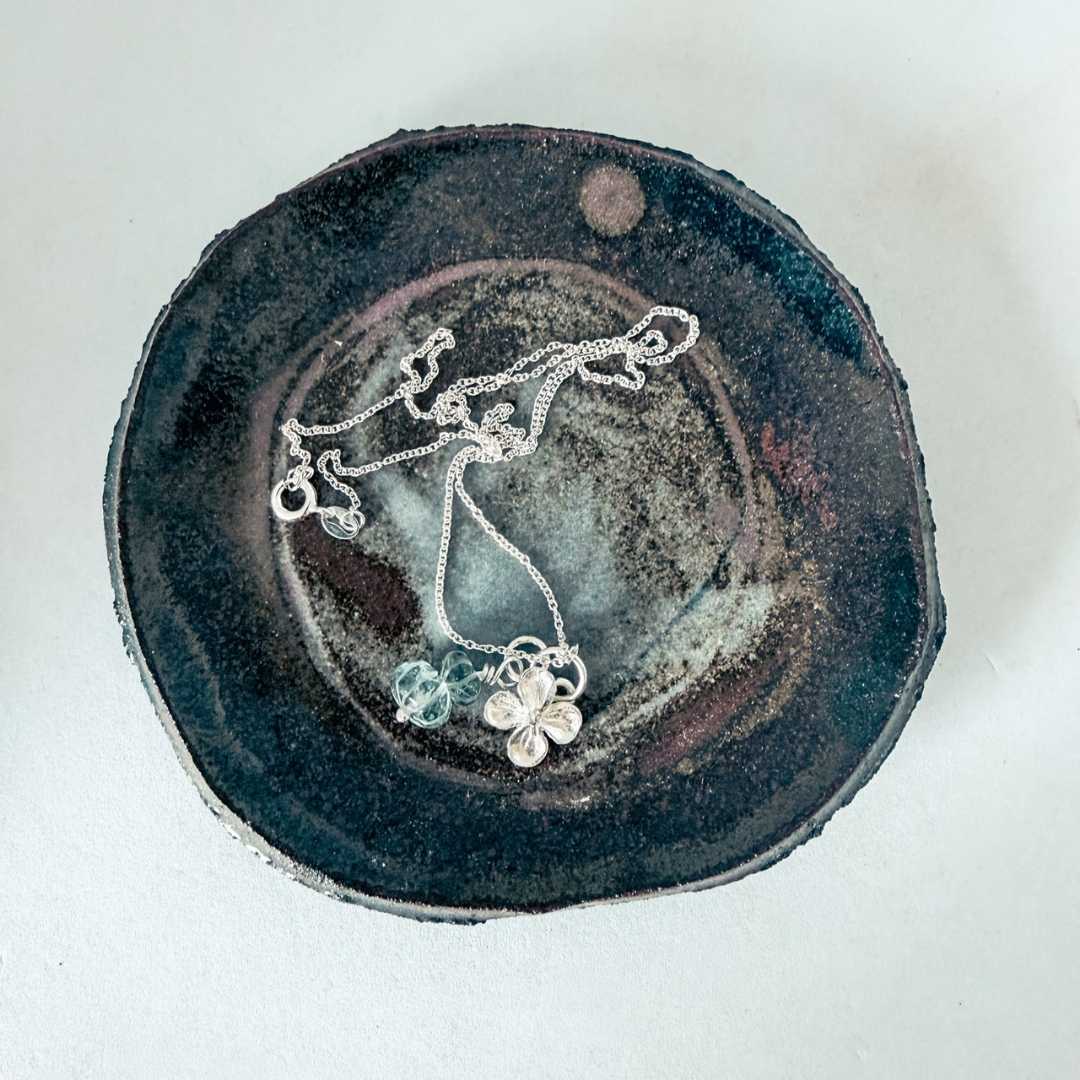 Hydrangea Flower Necklace with Aquamarine Beads in sterling silver resting on a handmade pottery dish, botanical jewellery by HerbertandWilks Auckland New Zealand
