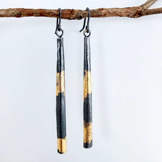 Keum-Boo pendant earrings in sterling silver with gold detail, 70mm long, hanging from a branch against a soft blue-grey background.
