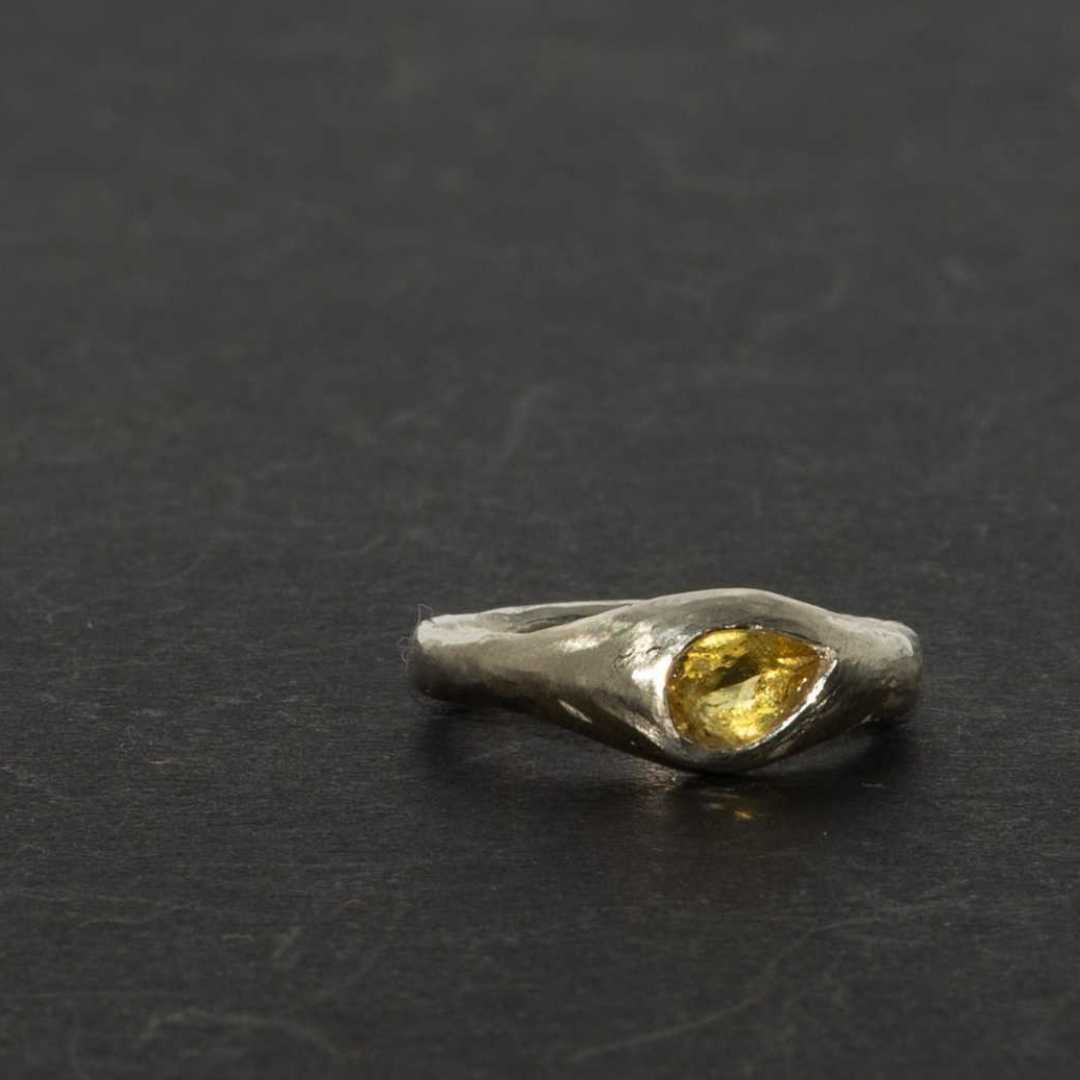 Kowhai sterling silver signet ring with a natural pear-shaped citrine gemstone, showcasing artisan hand-carved textures on a dark background.