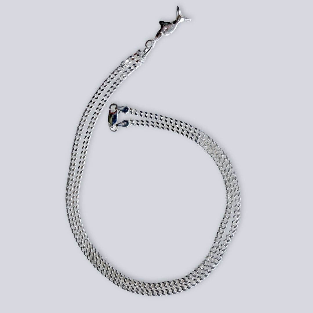 Mini Chomp sterling silver fish pendant on 50cm diamond-cut curb chain, shown laid flat.