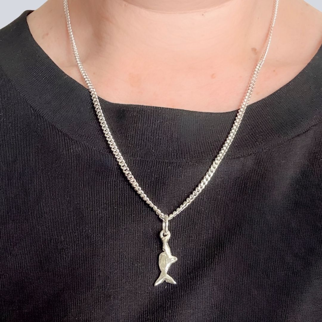 Mini Chomp sterling silver fish pendant worn on a 50cm diamond-cut curb chain.