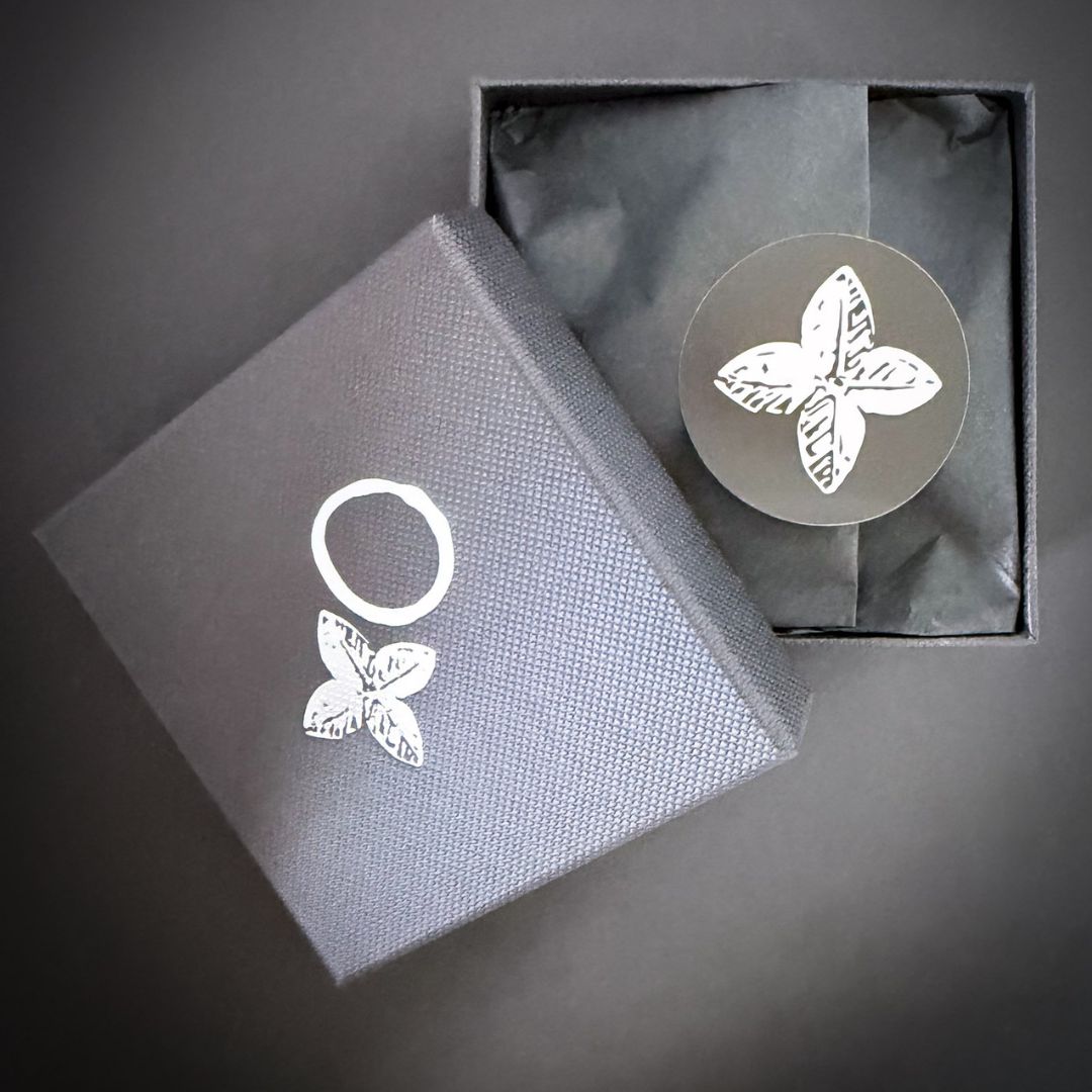 Organic Circle Hoop Earrings in sterling silver nestled behind black tissue paper in the HerbertandWilks gift box — the unboxing experience